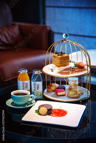 Elegant Afternoon Tea Set with Pastries and Coffee in Hotel Lounge