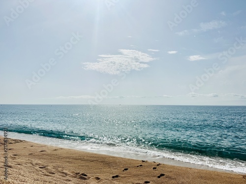 фотографія Footprints in Sand on Calm Beach with Turquoise Sea and Sky