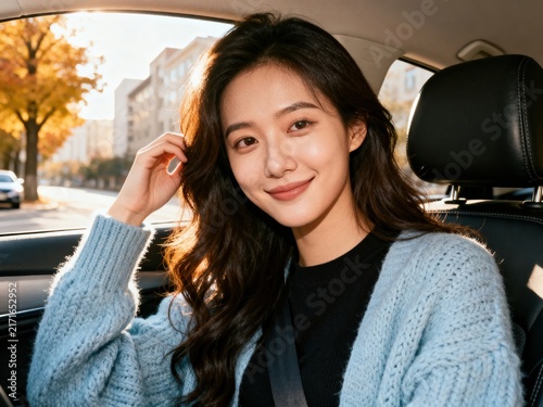 Smiling Woman Driver Sitting in Car at Sunset During Autumn Commute With Cozy Sweater

