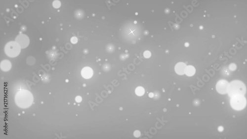 Glowing bokeh circles and soft light particles float against a monochromatic grey gradient background.