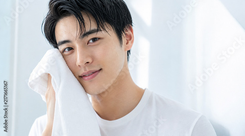 Plakat タオルで顔を拭く若い男性のスキンケアと美容のコンセプト