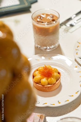Canvastavla Gourmet fruit tartlet with iced coffee on a cafe table for a luxury breakfast or