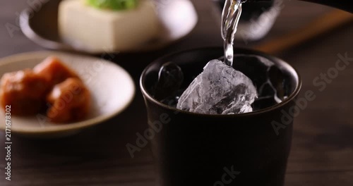 氷の入ったグラスに焼酎を注ぐ