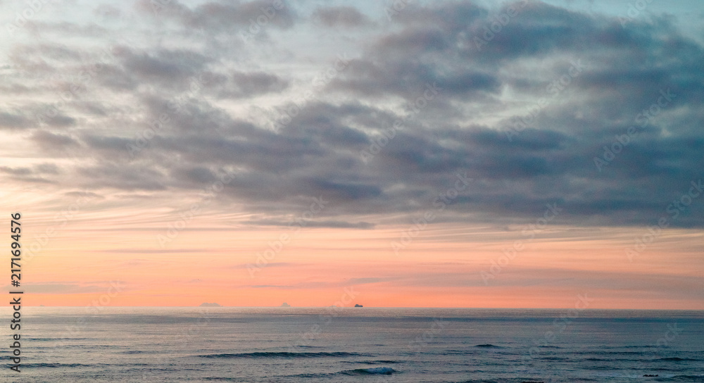Fototapeta premium Ship and islands on the ocean horizon at sunset