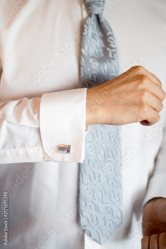 Obraz na plátne Man fastening the cufflink on his dress shirt