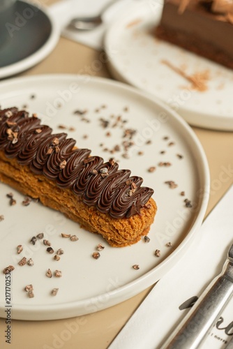 Foto Chocolate eclair pastry on a ceramic plate for gourmet dessert menu photography