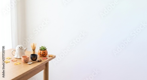 Minimalist Autumn Tea Setup with Cute Ghost and Pumpkin Decorations on a Table