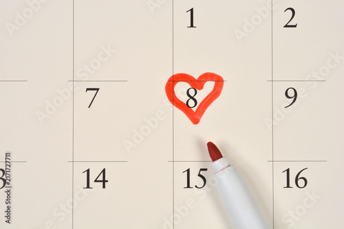 Bild auf Leinwand A red felt tip marker points to a hand drawn red heart symbol marking the number eight on a paper calendar page