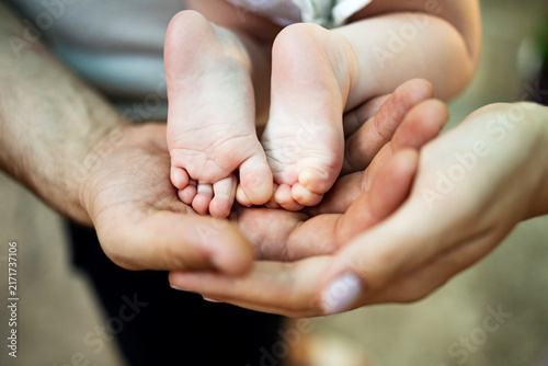 Fotografie Children's feet in the hands of mother and father