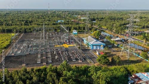 Aerial view of an electrical power station surrounded by green trees and forest in Indonesia
