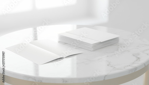Stack of blank white papers on a round marble table.