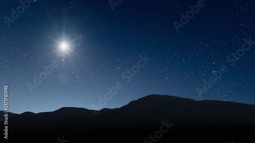 Glowing Christmas star above a peaceful mountain landscape with night sky