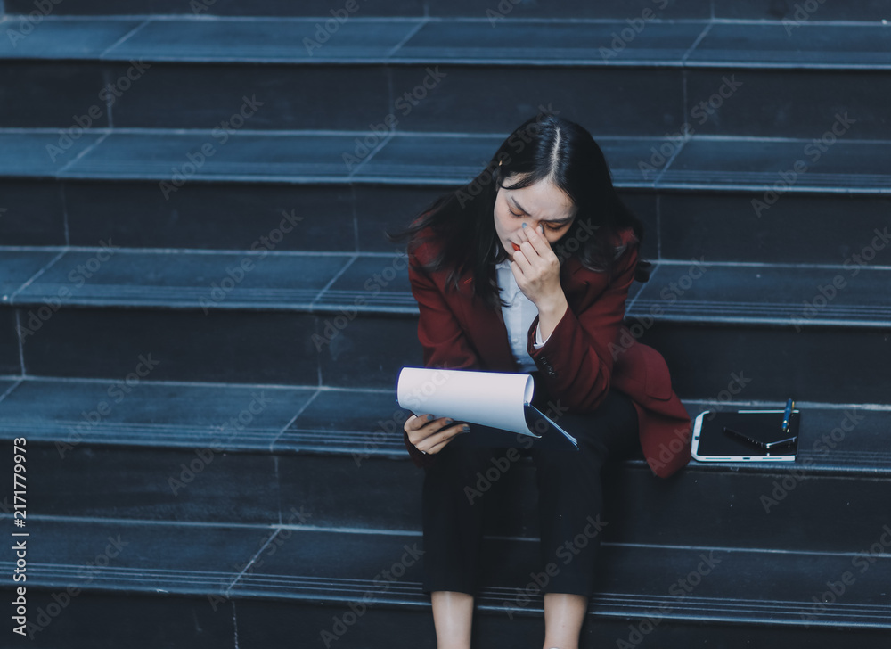 Fototapeta premium desperate Asian Korean business woman crying alone sitting on street staircase suffering stress and depression crisis being victim of mobbing or fired losing her job
