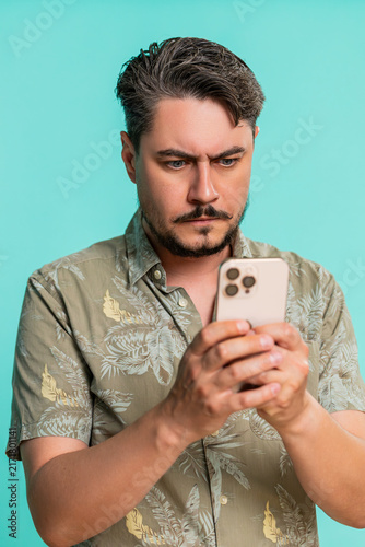 Bild auf Leinwand Middle-aged man anxiously types fast on smartphone, breathing deeply while focused on composing urgent message