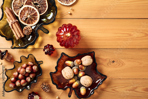 Autumn harvest decor with leaf shaped glass dishes on wooden background