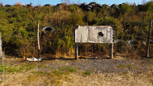 Obraz na plátne Paper Target Board with Bullet Holes at Outdoor Shooting Range