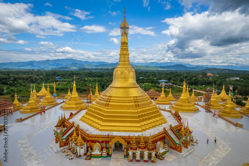 Фотография Aerial drone view of a magnificent main golden stupa surrounded by smaller pagodas and scenic nature at Pyitha Line Aye Pagoda, also known as Phra That Tagaw, Kayin State, Myanmar