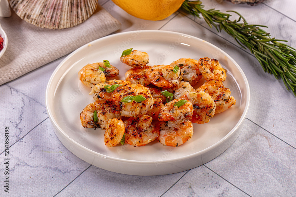 Fototapeta premium Grilled shrimp with herbs on white plate