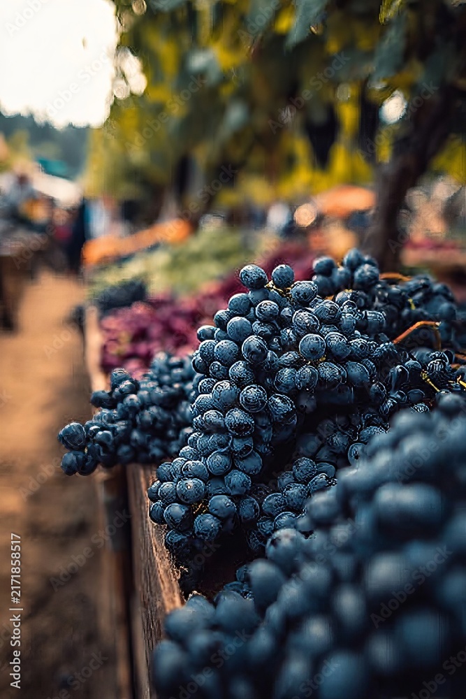 Naklejka premium Fresh Clusters of Dark Purple Grapes Displayed on a Wooden Table at a Rural Heritage Market Bazaar