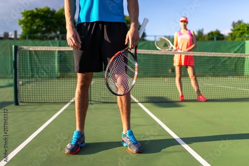 Foto Tennis player standing at the baseline holding a racket