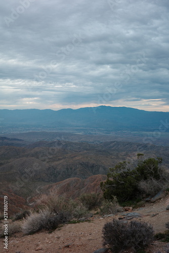 Warm dusk light over layered desert mountain ridges seen from a Joshua Tree National Park overlook, California