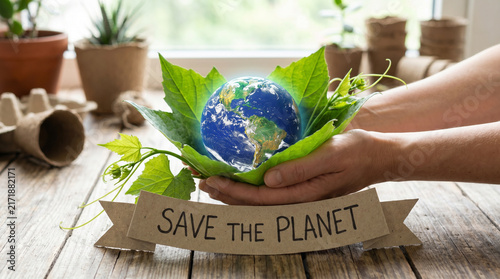 Human Hands Holding Planet Earth Globe in Green Leaves with Save The Planet Kraft Paper Ribbon