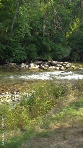 River rapidly flowing over the stone cascade in the forest