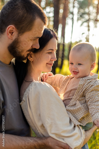 Happy family with baby enjoying a sunny day in the forest