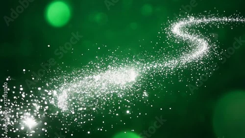 Magical green bokeh background with glowing winding trail of sparkling silver fairy dust particles
