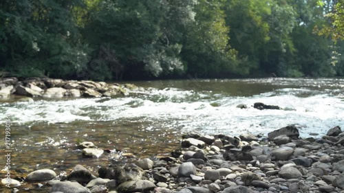 River rapidly flowing over the stone cascade in the forest