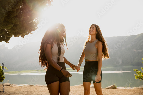 фотографія Happy female friends holding their hands together in a playful celebratory gestu