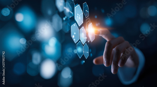 Person interacts with digital hexagon shapes on a dark background in a tech-related setting during evening hours