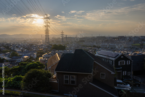 東京都日野市の郊外に広がる住宅街と送電鉄塔の夕景
