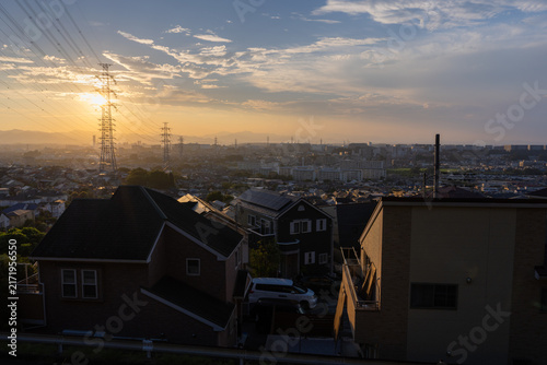 東京都日野市の郊外に広がる住宅街と送電鉄塔の夕景
