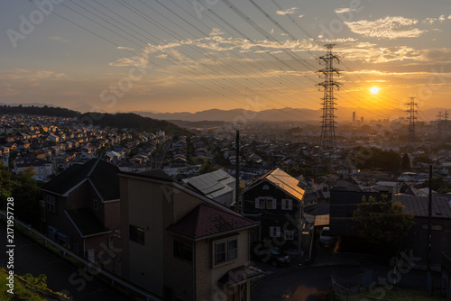 東京都日野市の郊外に広がる住宅街と送電鉄塔の夕景
