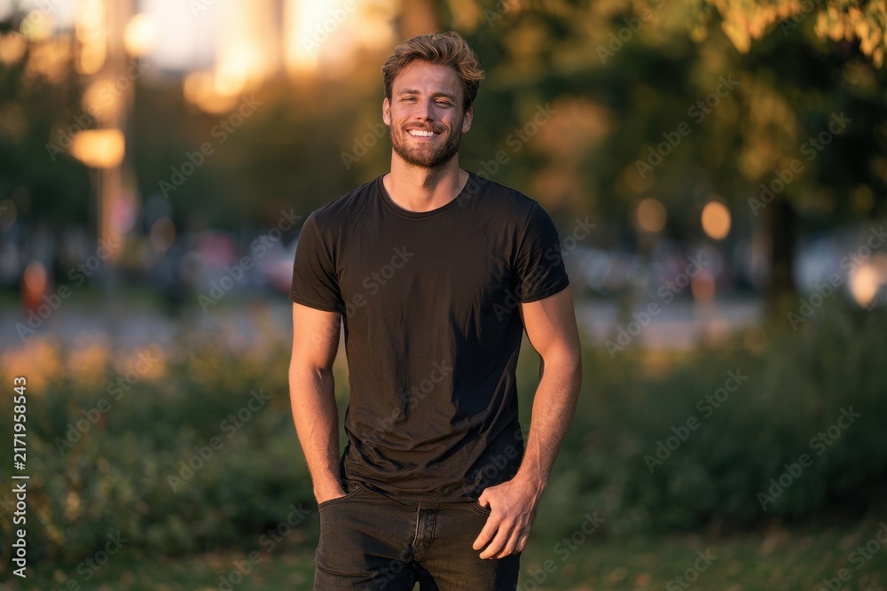 Obraz premium Bright candid portrait of a happy young man standing in an urban outdoor setting
