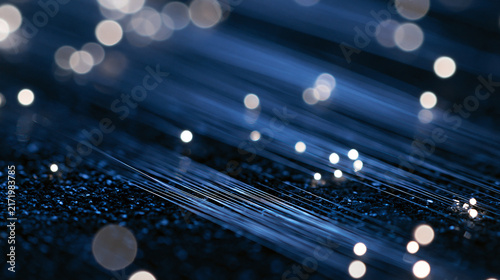 Macro view of blue fiber optic cables with glowing light pulses in the dark. A powerful visualization for high-speed internet and global connectivity concepts.