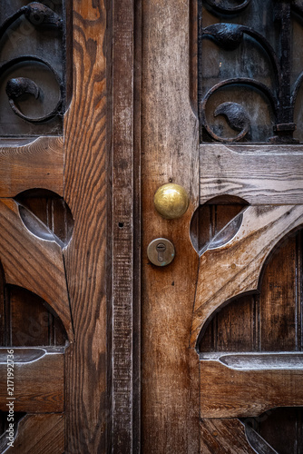 Ornate Wooden Double Door with Iron Scrollwork and Brass Knob
