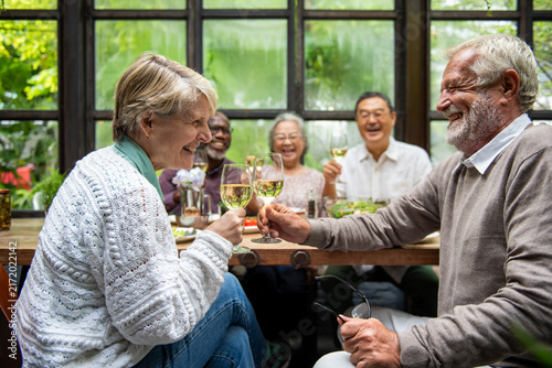 Joyful seniors enjoying wine together