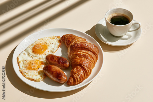 Breakfast Plate With Eggs Sausages And Croissant