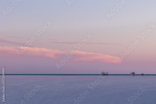 Fotografie intentional motion blur of people walking on beach at sunset on Florida island i