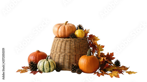 Autumn harvest display with pumpkins, gourds, pinecones, and fall leaves in a wicker basket isolated on transparent background