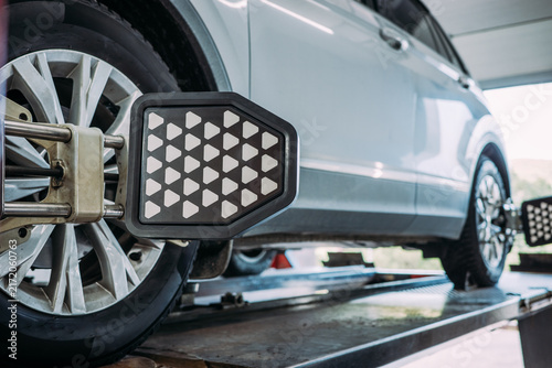 Принти на полотні Computerized wheel alignment target on SUV tire in repair shop, precision measurement of camber, caster and toe for suspension calibration and tire wear prevention