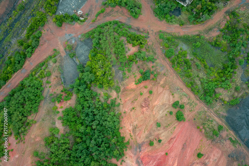 Konstfotografi Red soil degradation and mining waste land with green trees nature reclamation l
