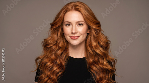 Beautiful Redhead Woman with Voluminous Long Wavy Copper Hair and Natural Makeup Portrait