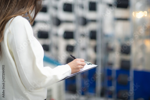 Quality Control Inspector Writing on Clipboard in Textile Factory