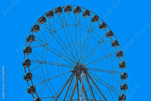 A fragment of the Ferris wheel at an amusement park on a summer day