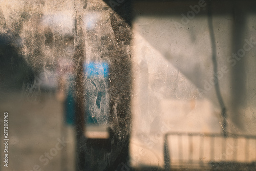 Foto Dirty, dusty, and scratched window glass surface against a dim interior backgrou