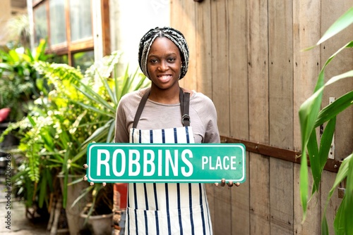 фотографія Smiling woman holding street sign.