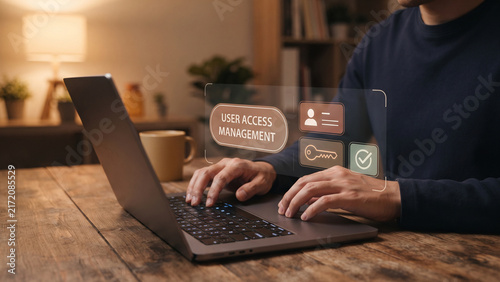 Man typing on laptop with user access management text and holographic icons, access control, permission management